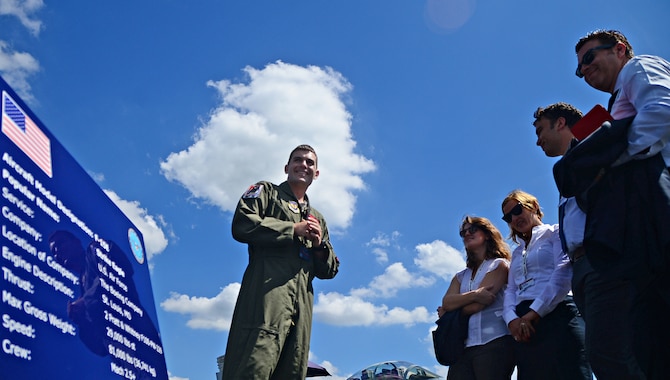 Capt. Tom Meyers discusses the F-15E Strike Eagle's capabilities with spectators July 17, 2014, at the Farnborough International Airshow in England. Public access was granted for spectators to ask questions and observe the aircraft up-close with pilots and aircrew members. Meyers is a 494th Fighter Squadron F-15E  instructor pilot. (U.S. Air Force photo/Airman 1st Class Erin O'Shea)