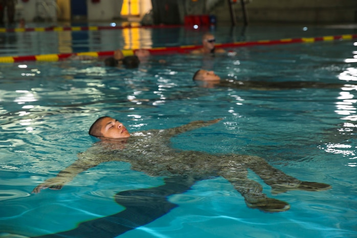Recruits of Kilo Company, 3rd Recruit Training Battalion, practice how to properly conduct an abandon ship jump from the three-meter board at Marine Corps Recruit Depot San Diego, July 21. Recruits are required to use proper technique during the drill, otherwise it is conducted again.