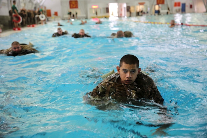 Recruits of Kilo Company, 3rd Recruit Training Battalion, conduct a 25-meter swim utilizing a back pack as a floatation device at Marine Corps Recruit Depot San Diego, July 21. The exercise was part of a swim qualification all recruits must pass in order to become Marines.