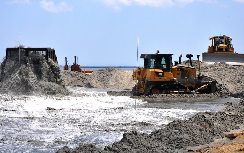 Bulldozers move newly-placed sand into position as it pumps onto the beach as a mixture of sand and water at Port Monmouth, New Jersey, on July 1, 2014, as part of dune and beach construction there where Hurricane Sandy’s impacts were severe. The dunes and beach are part of the first phase of a larger overall project designed to reduce coastal storm risks to the community. 