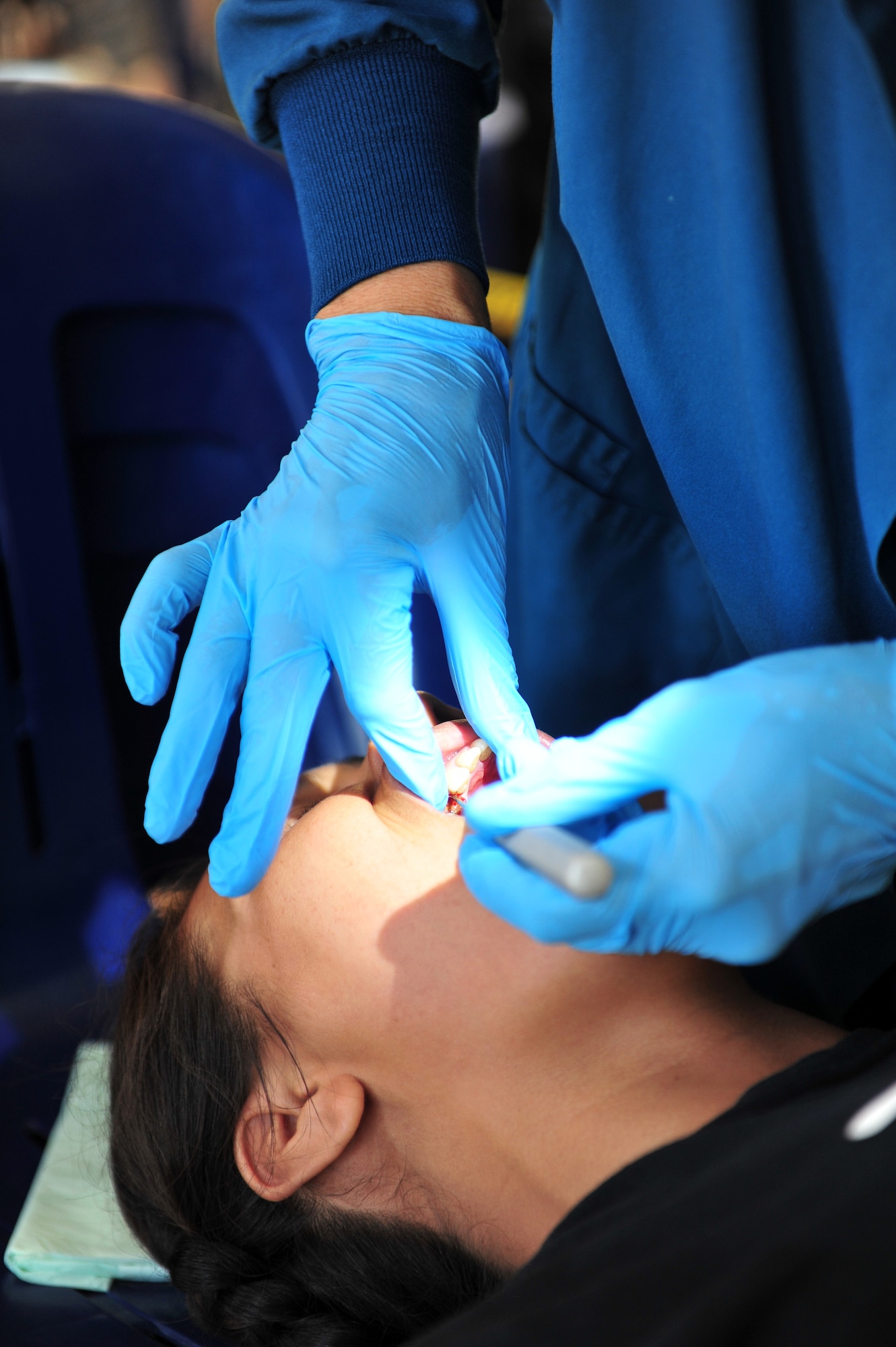 Lt. Col. Catherine Kanwetz  performs an extraction July 22, 2014, in Neiafu, Tonga. Pacific Angel-Tonga includes general health, dental, optometry, pediatrics, and engineering programs as well as various subject-matter expert exchanges. Kanwetz is deployed from the 152nd Air Base, Reno, Nev., and is the PACANGEL-Tonga lead dentist. (U.S. Air Force photo/Staff Sgt. Rachelle Coleman)