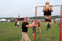 A female concert-goer conducts a flexed arm hang at RockFest 2014 in Cadott, Wisconsin. During the music festival, fans of Aerosmith and Rob Zombie conducted pull ups with the RS Twin Cities Marines.