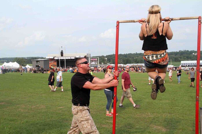 A female concert-goer conducts a flexed arm hang at RockFest 2014 in Cadott, Wisconsin. During the music festival, fans of Aerosmith and Rob Zombie conducted pull ups with the RS Twin Cities Marines.