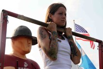 A female concert-goer conducts a flexed arm hang at RockFest 2014 in Cadott, Wisconsin. During the music festival, fans of Aerosmith and Rob Zombie conducted pull ups with the RS Twin Cities Marines.