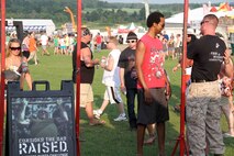Marines with Marine Corps Recruiting Station Twin Cities speak to concert-goers at RockFest 2014 in Cadott, Wisconsin. During the music festival, fans of Aerosmith and Rob Zombie conducted pull ups with the RS Twin Cities Marines.