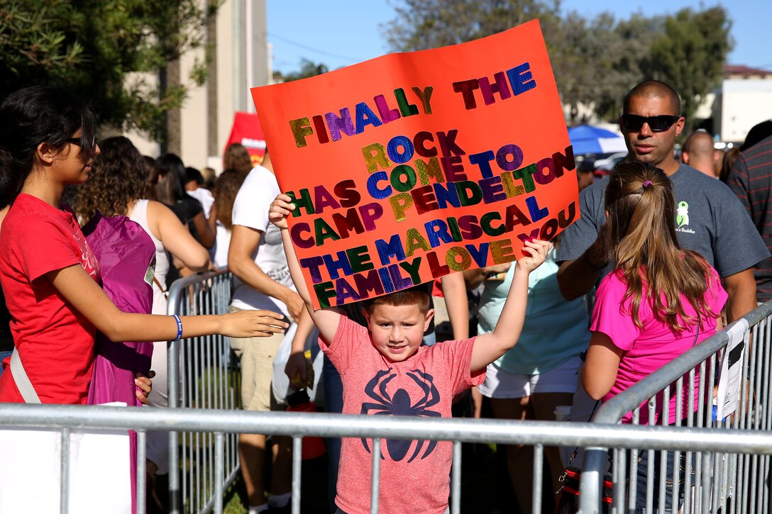 Marcos, 6, holds up a sign with the catch phrase "Finally the rock has come to..." that actor Dwayne "The Rock" Johnson often says when he visits new places

Johnson took photos with fans before the screening of his new movie "Hercules" at the base theater here July 24.