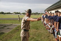 Sergeant Rafael Garnica, a Company M, 3rd Recruit Training Battalion, Marine Corps Recruit Depot San Diego drill instructor, instructs poolees to move closer to one another during Marine Corps Recruiting Station Kansas City's all-hands pool function at Camp Clark in Nevada, Mo., June 20, 2014. Drill Instructors from both MCRD San Diego and Parris Island participated in the pool function to give poolees their first taste of what to expect at recruit training. 