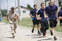 Sergeant Rafael Garnica, a Company M, 3rd Recruit Training Battalion, Marine Corps Recruit Depot San Diego drill instructor, hustles poolees to their next location during Recruiting Station Kansas City's all-hands pool function at Camp Clark in Nevada, Mo., June 20, 2014. Garnica, and other drill instructors from MCRD San Deigo and Parris Island were on hand to give poolees their first tast of what to expect when at recruit training.