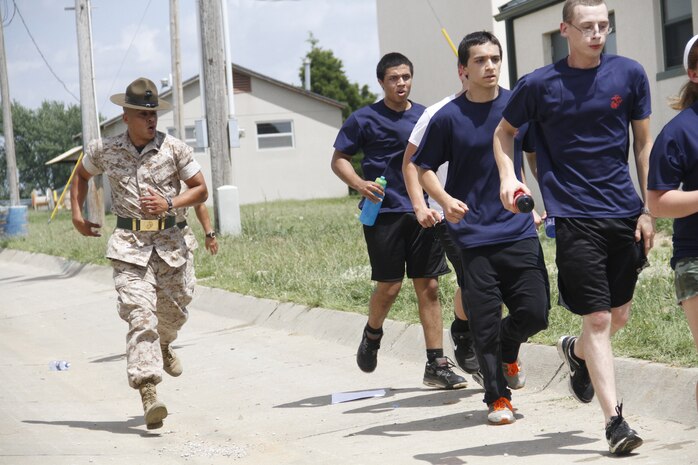 Sergeant Rafael Garnica, a Company M, 3rd Recruit Training Battalion, Marine Corps Recruit Depot San Diego drill instructor, hustles poolees to their next location during Recruiting Station Kansas City's all-hands pool function at Camp Clark in Nevada, Mo., June 20, 2014. Garnica, and other drill instructors from MCRD San Deigo and Parris Island were on hand to give poolees their first tast of what to expect when at recruit training.