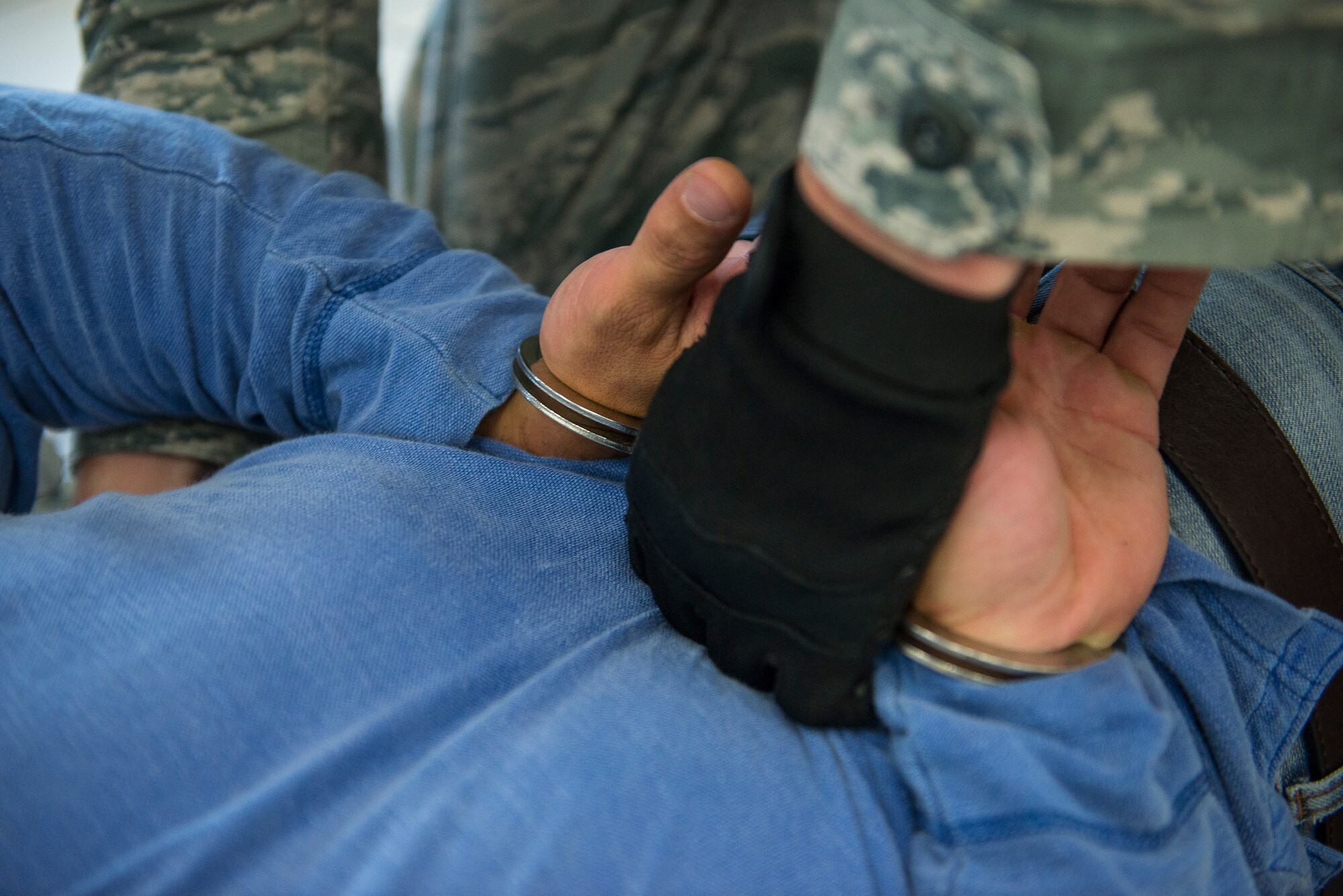 A 51st Security Forces Squadron personnel handcuffs a simulated gunman during an active-shooter exercise July 24, 2014, at Osan Air Base, Republic of Korea. During exercise Beverly Midnight 14-3, the bae was tested on emergency management scenarios, which included multiple active-gunman scenarios in the Base Exchange and other buildings. (U.S. Air Force photo by Staff Sgt. Jake Barreiro)