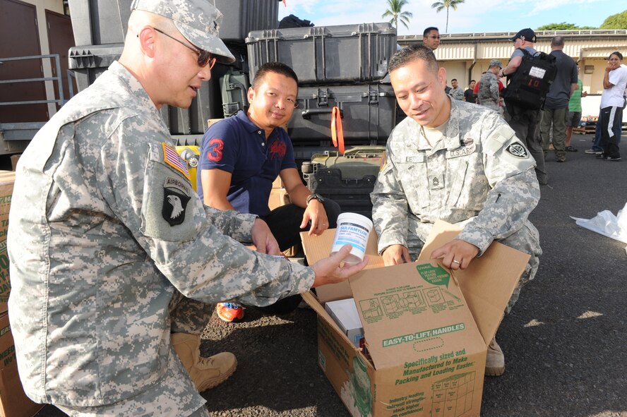Army Col. Tuan Ton, Pacific Command’s desk officer, (left) prepares a box of burn cream with Army Sgt. 1st Class Kelvin Ngo, and Sgt. 1st Class  Phong Le, both from Joint POW/MIA Accounting Command, July 22, 2014, at Joint Base Pearl Harbor-Hickam, Hawaii. (U.S. Air Force photo/Master Sgt. Matthew McGovern)