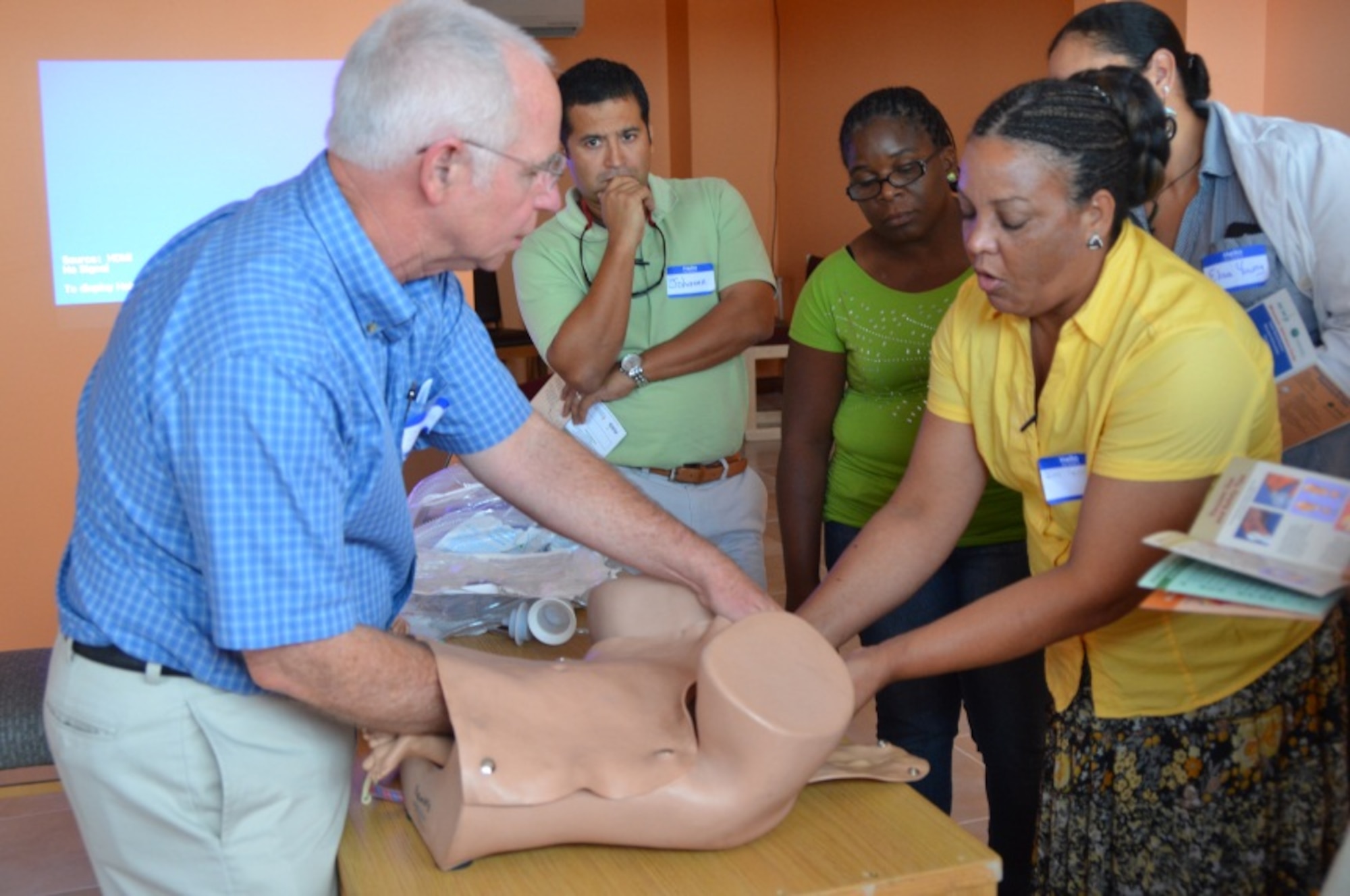 Dr. Robert Persons, Doctor of Osteopathic Medicine and Fellow of the American Academy of Family Practice and Joan Arana teach a group of Belizean healthcare professionals how to perform an assisted vaginal delivery during the Global Advanced Life Support in Obstetrics Instructor Course in Belize City, Belize, July 23, 2014. (Courtesy Photo)