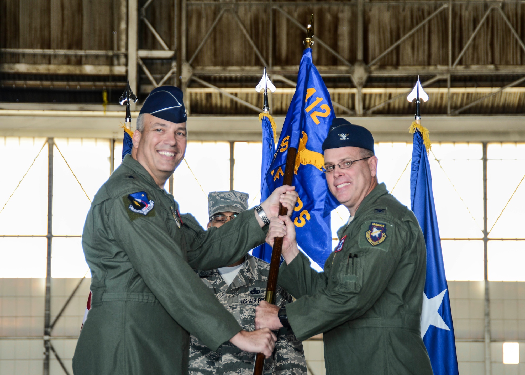Brig. Gen. Michael Brewer (left), 412th Test Wing commander, presents Col. Charles Webb (right) with the unit guidon signifying Webb's assumption of command as the new USAF Test Pilot School commandant July 24. (U.S. Air Force photo by Rebecca Amber) 