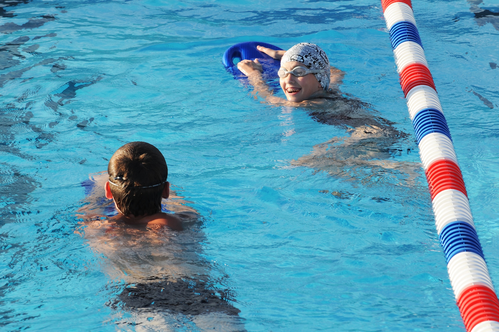 Bruce Crabtree and Lilliana Ward do warm-up laps at the beginning of swim practice at Scott Air Force Base, Ill., July 16, 2014.  Twice a week during the summer, swimmers came to the base pool to work on swimming techniques to make them stronger and faster in the water.  Crabtree and Ward are swimmers for the Scott Sharks.  (U.S. Air Force photo by Staff Sgt. Maria Bowman)
