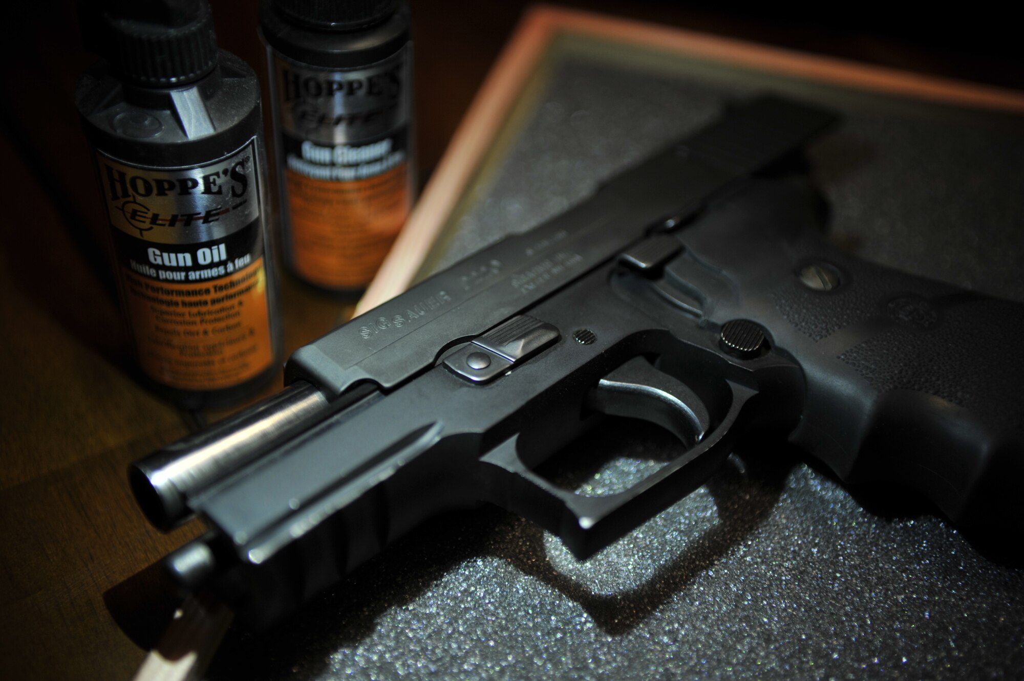 A Sig Sauer P220’s slide is locked to the rear on a table at Laughlin Air Force Base, Texas, July 22, 2014. Gun owners are responsible for knowing the laws governing ownership in their state and all base regulations, and must be well versed in the function and operation of their firearm to safely operate it. (U.S. Air Force Photo by Senior Airman Nathan Maysonet)(Released)  