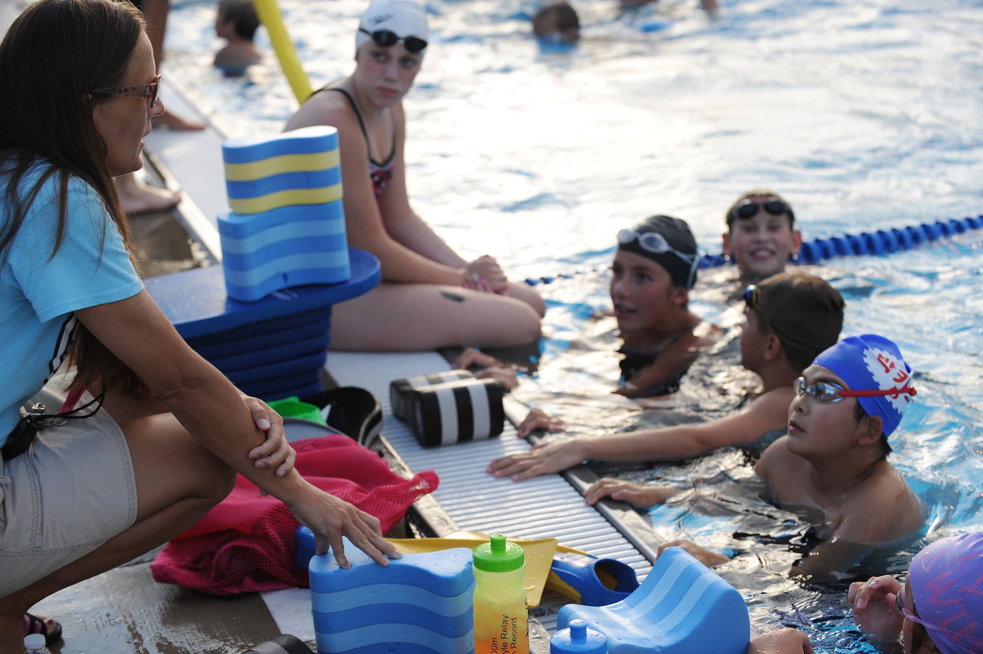 Sharon Wilda gives instructions on the high-elbow pull of the freestyle stroke at Scott Air Force Base, Ill., July 16, 2014.  During a high-elbow pull, a swimmer’s hand will enter and leave the water at nearly the exact same point during a single stroke cycle, reducing frontal drag.  With practice, this technique can make a swimmer stronger and faster in a pool.  Wilda is a coach for the Scott Sharks.  (U.S. Air Force photo by Staff Sgt. Maria Bowman)