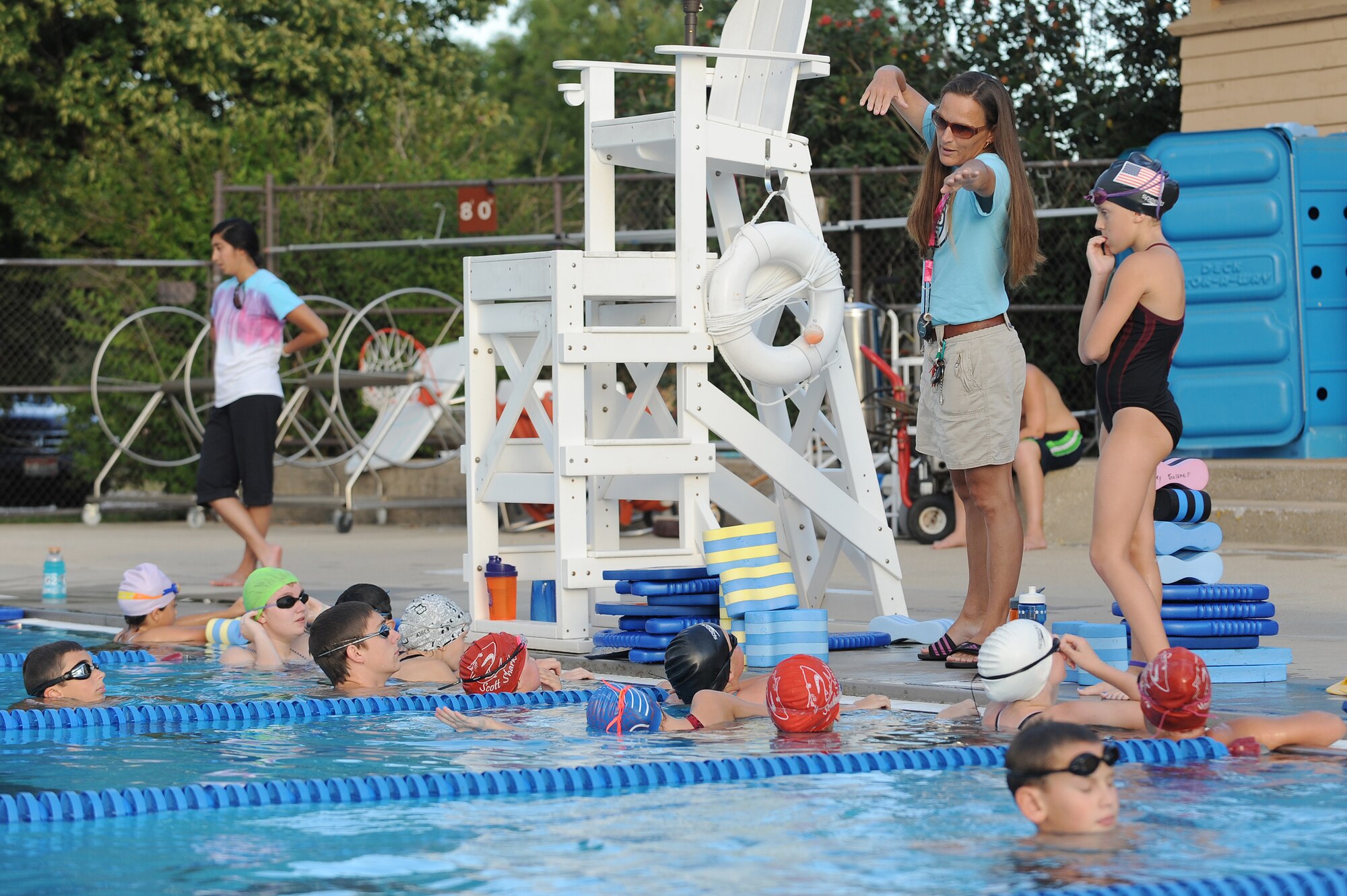 Sharon Wilda gives instructions on the high-elbow pull of the freestyle stroke at Scott Air Force Base, Ill., July 16, 2014.  During a high-elbow pull, a swimmer’s hand will enter and leave the water at nearly the exact same point during a single stroke cycle, reducing frontal drag.  With practice, this technique can make a swimmer stronger and faster in a pool.  Wilda is a coach for the Scott Sharks.  (U.S. Air Force photo by Staff Sgt. Maria Bowman)