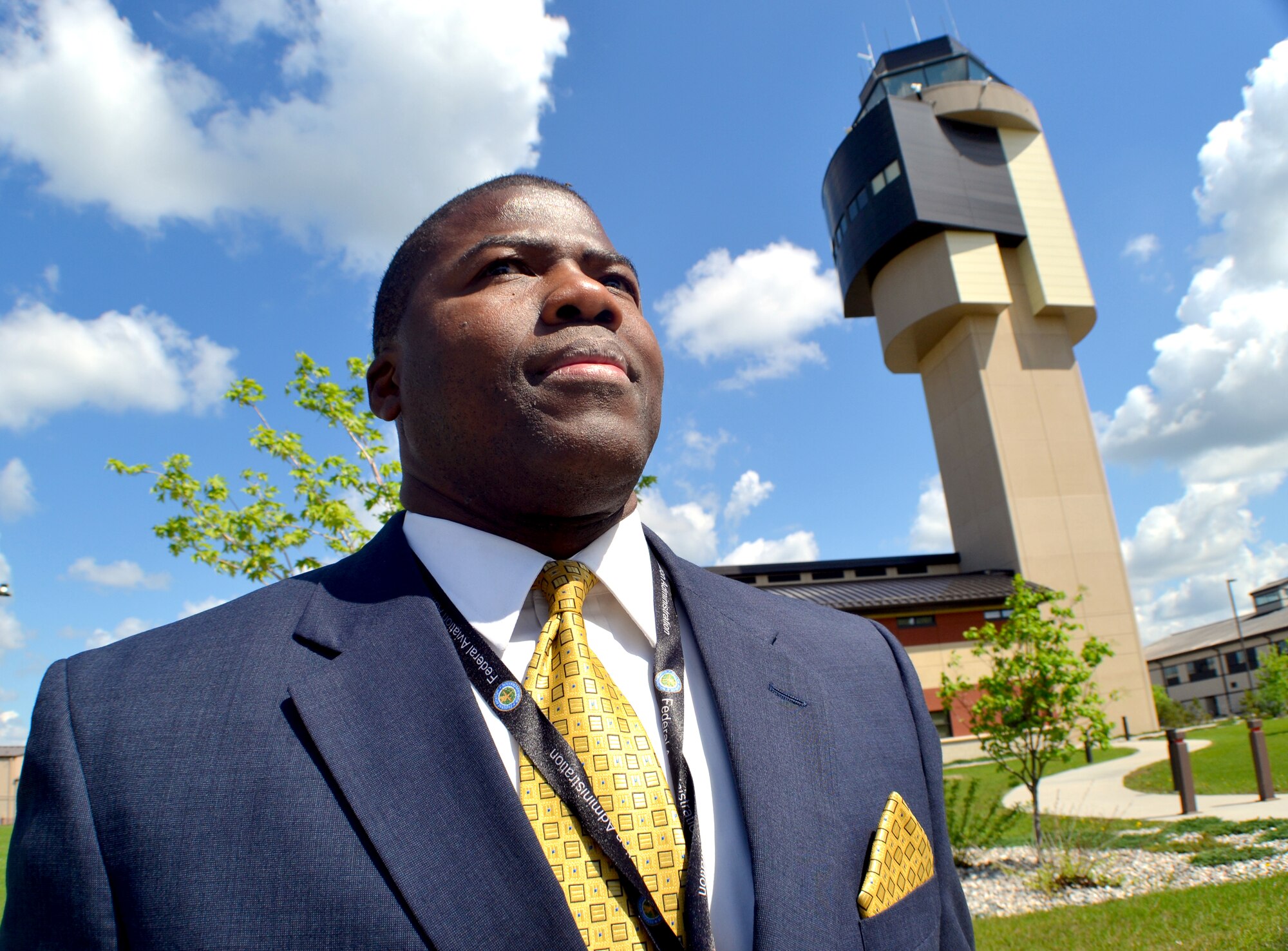 Federal Aviation Administration air traffic controller, Marvin Sutton, from the Air Route Traffic Control Center in Fort Worth, Texas, poses for a photo in front of the air traffic control tower at Grand Forks Air Forks Air Force Base, N.D., on June 3, 2014. Grand Forks AFB was Sutton's first permanent duty station during his 8-years of service in the Air Force. He helped keep aircraft and people on base safe as a security forces Airman. The former Warrior of the North became an Air Force air traffic controller before separating as a staff sergeant in 1988, but continued to protect people and aircraft as a civilian ATC. He visited his first duty station to talk with some Air Force traffic controllers. “The military was great stepping stone for me because it provided me with an opportunity to learn a set of skills and gain experiences that I was able to use as I transitioned back into civilian life and be successful,” said Sutton. (U.S. Air Force photo/Staff Sgt. Luis Loza Gutierrez)