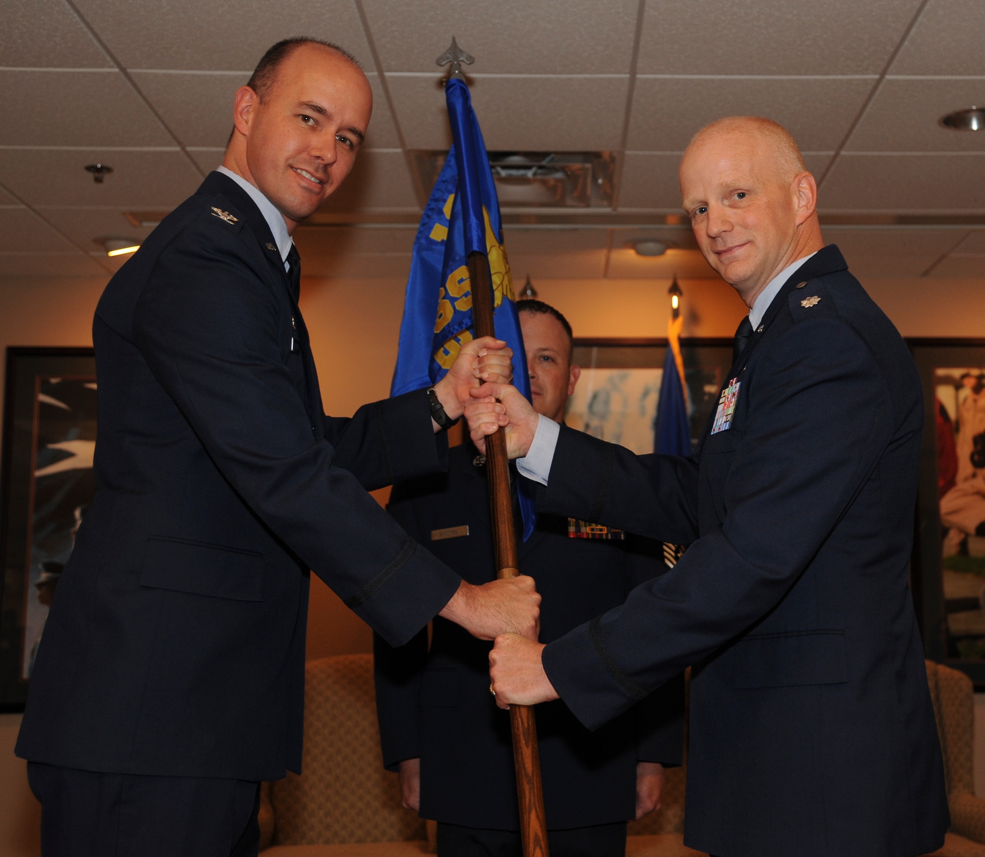 Col. Douglas Littlefield, 19th Medical Group commander, passes the guidon to Lt. Col. Dean Farrey, 19th Medical Support Squadron commander, July 21, 2014, at Little Rock Air Force Base, Ark. (U.S. Air Force photo by Airman 1st Class Harry Brexel)