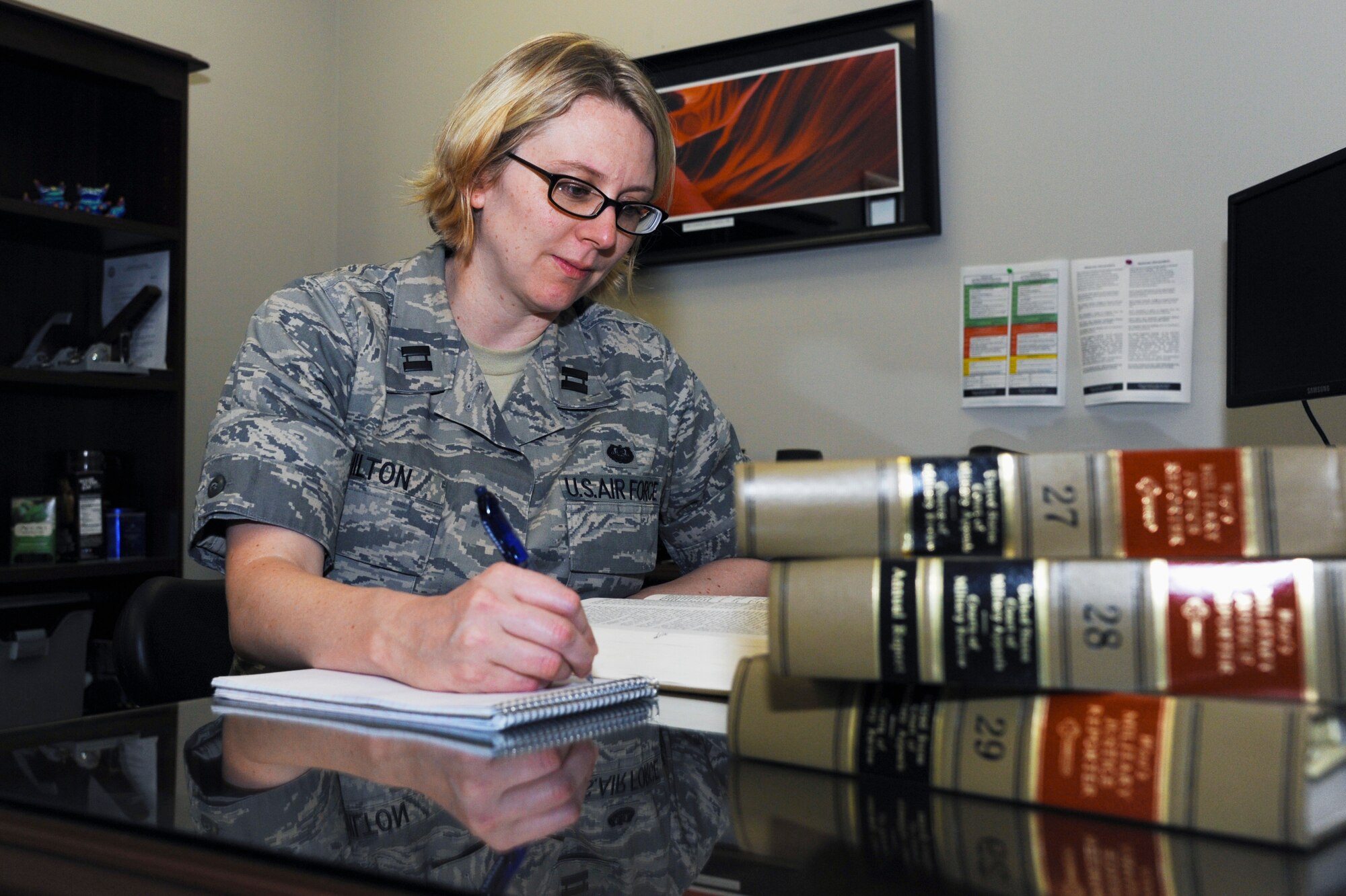 Capt. Theresa Hilton, Air Force Legal Operations Agency Area Defense Counsel, looks up an excerpt from one of her legal books July 21, 2014, at Little Rock Air Force Base. Hilton, an Ocean City, N.J., native, uses her leadership, strategic planning and investigative skills to eradicate and clarify any misunderstandings or false accusations of her clients.  (U.S. Air Force photo by Airman 1st Class Mercedes Muro)