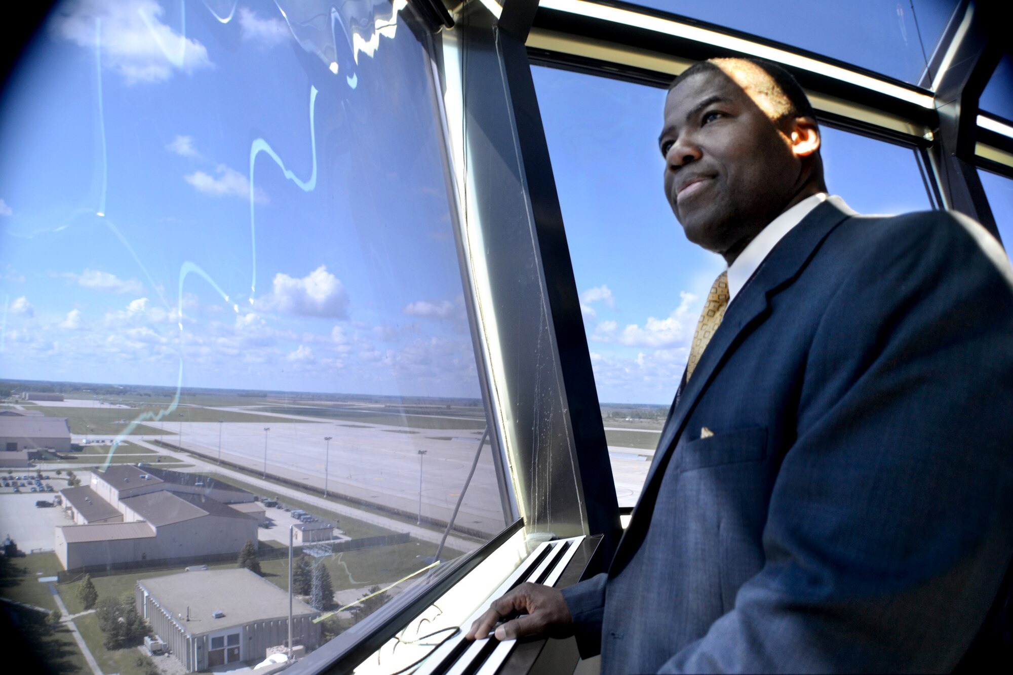 Federal Aviation Administration air traffic controller, Marvin Sutton, from the Air Route Traffic Control Center in Fort Worth, Texas, quietly takes in the panoramic view on June 3, 2014, from the air traffic control tower at Grand Forks Air Forks Air Force Base, N.D. Grand Forks AFB was Sutton's first permanent duty station during his 8-years of service in the Air Force. He helped keep aircraft and people on base safe as a security forces Airman. The former Warrior of the North became an Air Force air traffic controller before separating as a staff sergeant in 1988, but continued to protect people and aircraft as a civilian ATC. He visited his first duty station to talk with some Air Force traffic controllers. “The military was great stepping stone for me because it provided me with an opportunity to learn a set of skills and gain experiences that I was able to use as I transitioned back into civilian life and be successful,” said Sutton. (U.S. Air Force photo/Staff Sgt. Luis Loza Gutierrez)
