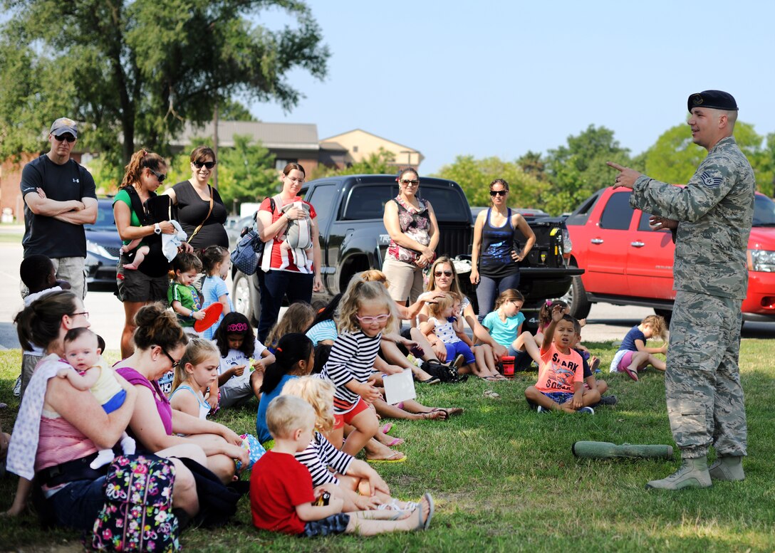 Staff Sgt. Christopher Rutkowski tells a crowd of Team Andrews members about the 11th Wing Security Support Squadron's Military Working Dog mission at the library at Joint Base Andrews, Md., July 23, 2014.  The library hosted the MWD demonstration as part of its "Paws to Read" summer reading program, which runs through Aug. 9.  Rutkowski is an 11th SSPTS MWD trainer. (U.S. Air Force photo/Staff Sgt. Torey Griffith)