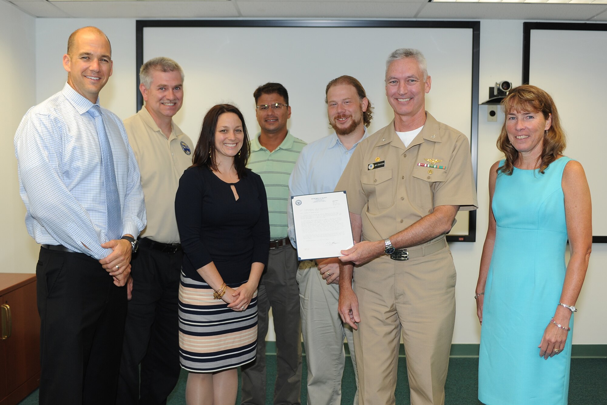 Capt. James Donnelly, second from right, and Kathleen Donnelly, right, present several members of the Advanced Arresting Gear (AAG) Thermal Management Fluid Working Group with Letters of Appreciation for their work in identifying an acceptable fluid substitute for the USS Gerald. R. Ford (CVN 78) AAG water twister July 23, 2014, at Joint Base McGuire-Dix-Lakehurst, N.J. From left to right, Sean Brennan, Joseph Kirk, Sara Federico and Scott Stapleton all received Letters of Appreciation. Kevin Larkins, third from right, received the Affordability Championship Award . (U.S. Navy courtesy photo/Released)