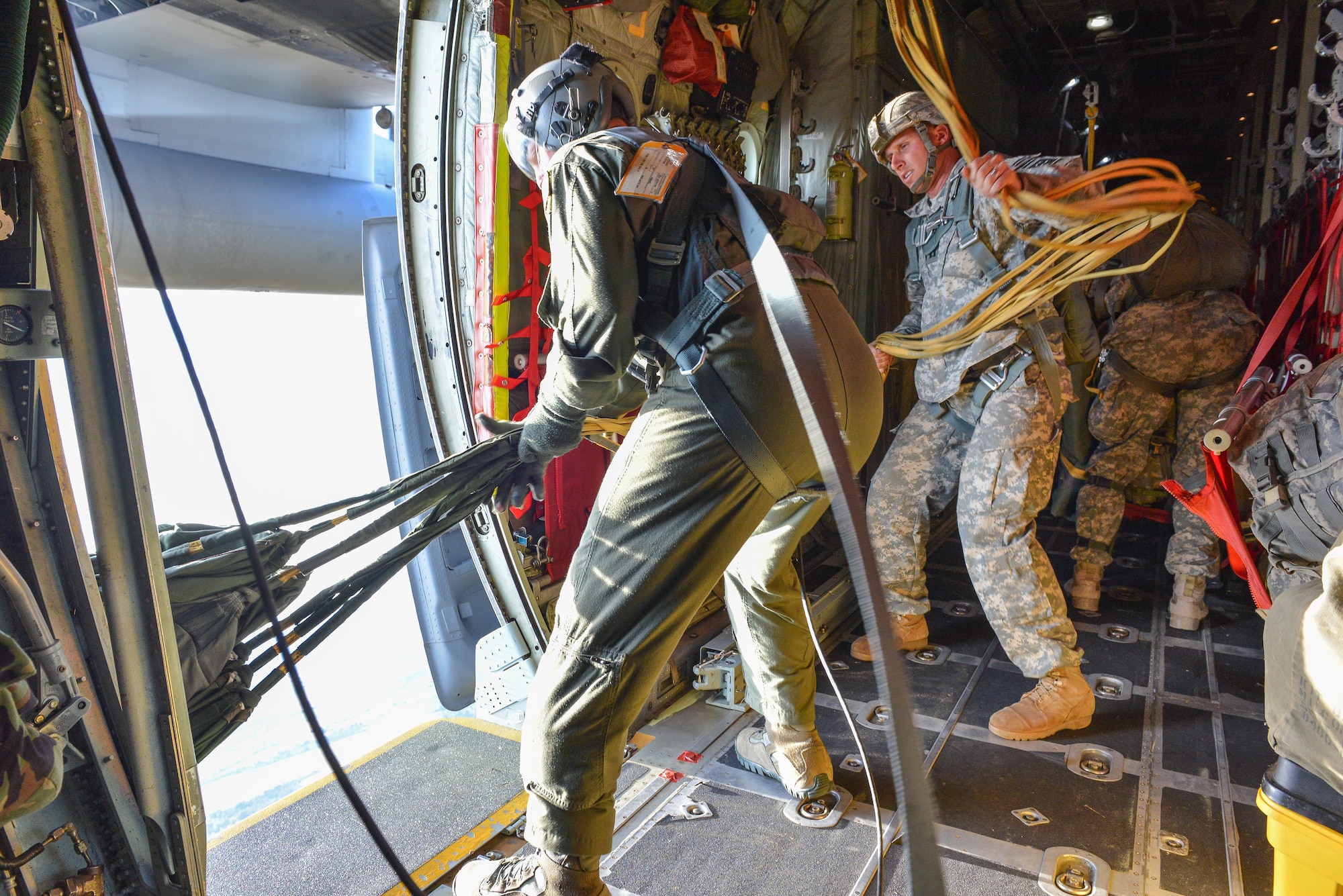 U.S. Air Force Senior Master Sgt. Mitch McCooley from the 165th Airlift Wing, Georgia Air National Guard, pulls in parachute bags May 29, 2014, over Corsica, France. The 82nd Airborne Jumpmasters provided training for French jumpers to learn U.S. Army techniques and use American equipment as part of a U.S. French exercise. (U.S. Air National Guard photo by Master Sgt. Charles Delano/released)