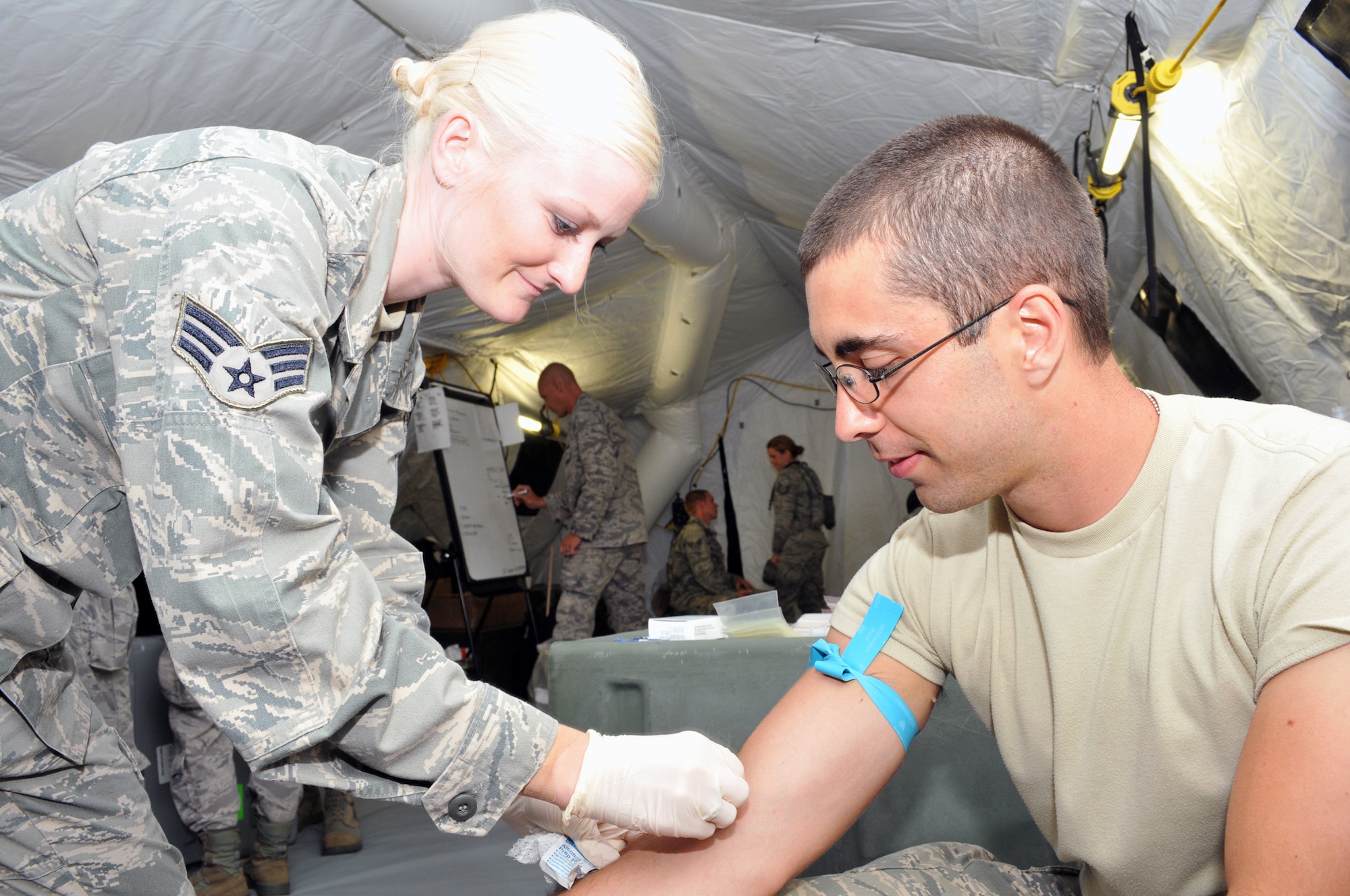 Senior Airman Kristen Hill (left) and Airman 1st Class Paul Longwroth (right) from the Nevada Air National Guard 152nd Medical Group hone their skills of performing medical lab work in field conditions during the National Guard PATRIOT 2014 exercise at Volk Field, Wis. Several units of the Air National Guard, Army National Guard and Reserve units from several states are working with local, state, and national organizations to train on, perform, and assess their ability to respond to multiple emergencies.