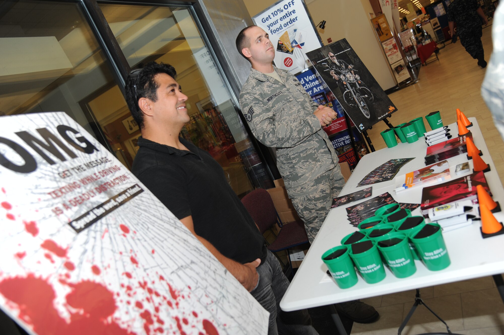 Erwin Urias, “Globe of Death” motorcycle performer, and Staff Sgt. Thomas Northcutt, 81st Training Wing, provide information about traffic safety July 23, 2014, at the base exchange, Keesler Air Force Base, Miss.  The wing safety office hosted the traffic safety day event which included information about the Airmen Against Drunk Driving program and motorcycle safety tips.  (U.S. Air Force photo by Kemberly Groue)
