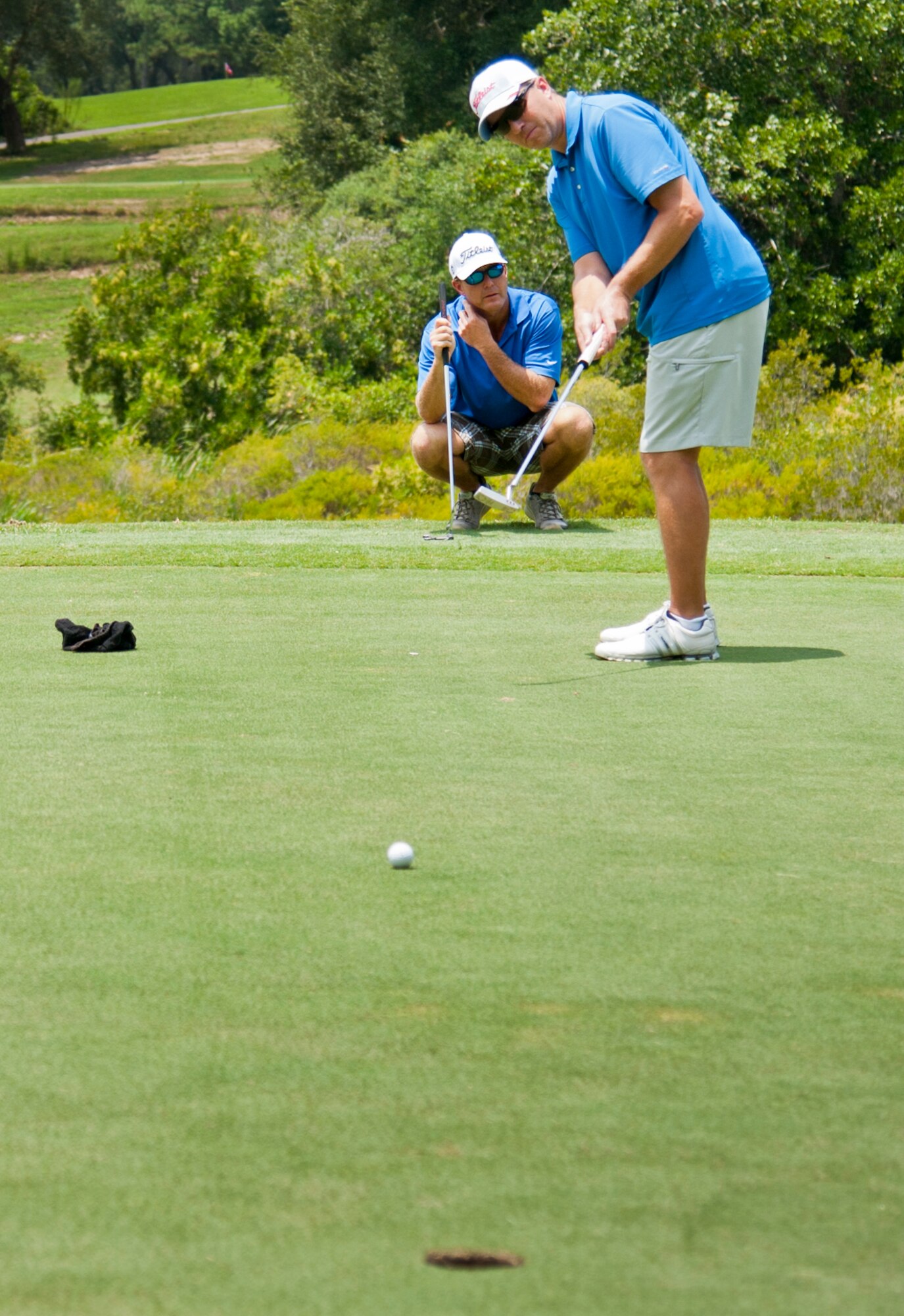 7/24/2014 – The 53rd Wing’s Maj. Brian Balcer, looks on as Jeff Kile, sinks a putt from 15 feet for a birdie at the Par 3 second hole of the base intramural golf championship at the Eglin Golf Course July 23.  The Air Force Research Lab team played against the 53rd WG team and prevailed to take the championship. (U.S. Air force photo/Ilka Cole)