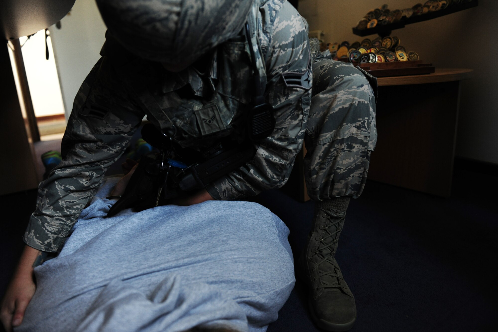 Airman 1st Class Hannah Gola, 422nd Security Forces Squadron patrolman, searches the body of Tech. Sgt. Ajenna Smith, 422nd SFS noncommissioned officer in charge of training and simulated-active shooter, during an exercise at RAF Croughton, United Kingdom, July 22, 2014. Active shooter exercises are held to ensure personnel know how to quickly and properly respond if such an incident were ever to actually occur. (U.S. Air Force photo by Staff Sgt. Jarad A. Denton/Released)