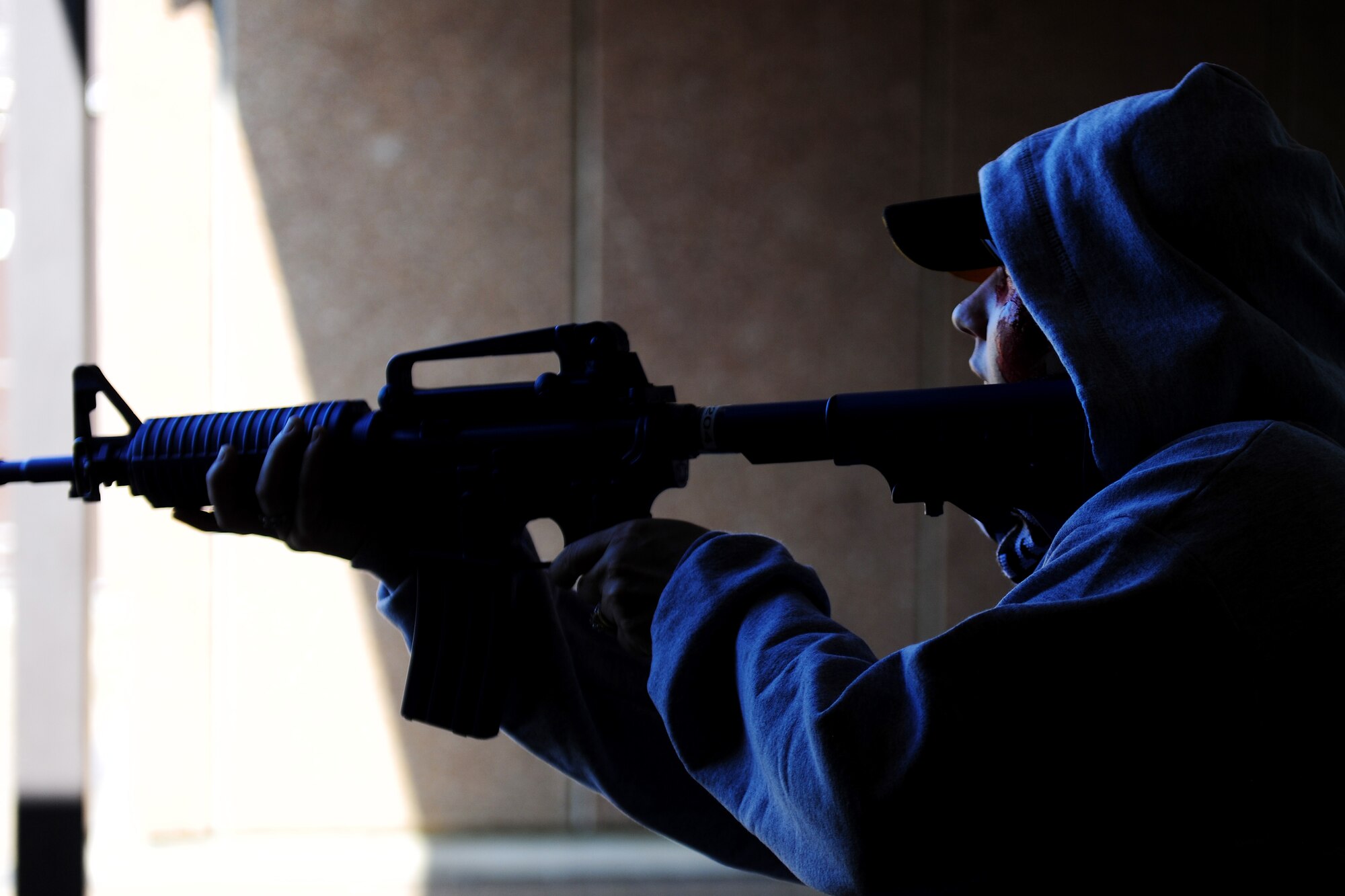 Tech. Sgt. Ajenna Smith, 422nd Security Forces Squadron noncommissioned officer in charge of training and simulated-active shooter, opens fire upon Airmen during an exercise at RAF Croughton, United Kingdom, July 22, 2014. Smith said many active shooters feel angry about a situation in their lives and think the only recourse is to violently act out against innocent bystanders. (U.S. Air Force photo by Staff Sgt. Jarad A. Denton/Released)