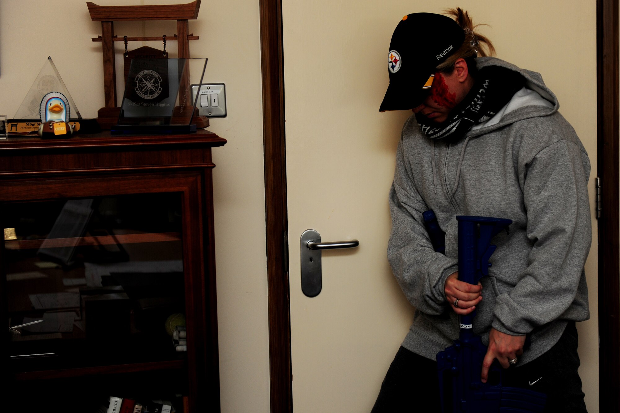 Tech. Sgt. Ajenna Smith, 422nd Security Forces Squadron noncommissioned officer in charge of training and simulated-active shooter, braces the door of an office during an exercise at RAF Croughton, United Kingdom, July 22, 2014. After her rampage, Smith found an unlocked and empty room where she could hide from Security Forces before either continuing her assault or ending her own life. (U.S. Air Force photo by Staff Sgt. Jarad A. Denton/Released)