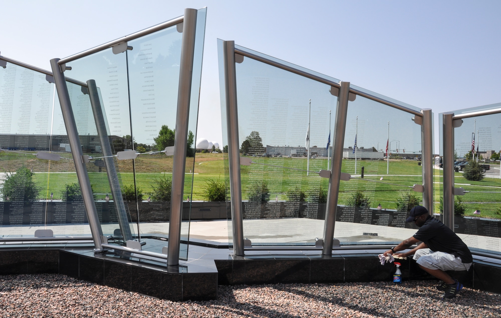 Master Sgt. Kinshasa Smith, Team Buckley Top 3 member, cleans the Colorado Freedom Memorial July 18, 2014, in Aurora, Colo. Buckley Air Force Base members have begun the new initiative to take care of the memorial at least once every month. (U.S. Air Force photo by Staff Sgt. Nicholas Rau/Released)
