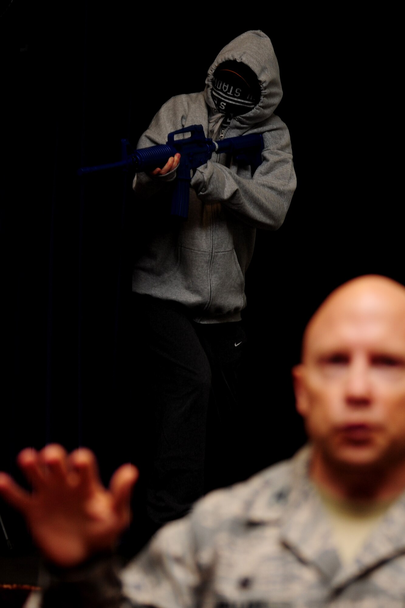Tech. Sgt. Ajenna Smith, 422nd Security Forces Squadron noncommissioned officer in charge of training and simulated-active shooter, opens fire on a crowd during a commander’s call at RAF Croughton, United Kingdom, July 22, 2014. Smith said her goal during this training exercise was to kill as many people as possible in a short amount of time. (U.S. Air Force photo by Staff Sgt. Jarad A. Denton/Released)