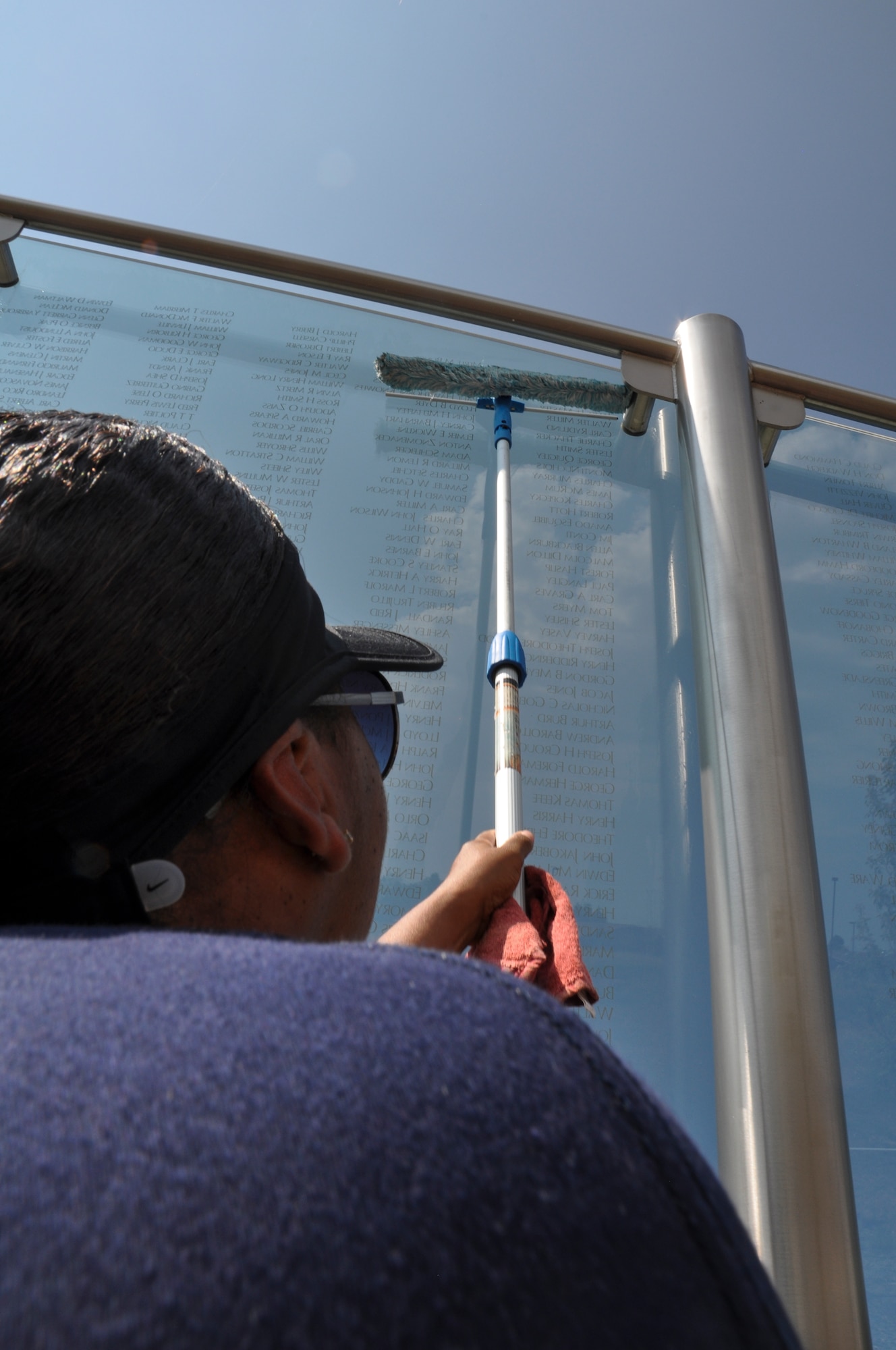 Master Sgt. Pourshia Chambers-Motley, Team Buckley Top 3 member, cleans the Colorado Freedom Memorial July 18, 2014, in Aurora, Colo. Buckley Air Force Base members have begun the new initiative to take care of the memorial at least once every month. (U.S. Air Force photo by Staff Sgt. Nicholas Rau/Released)