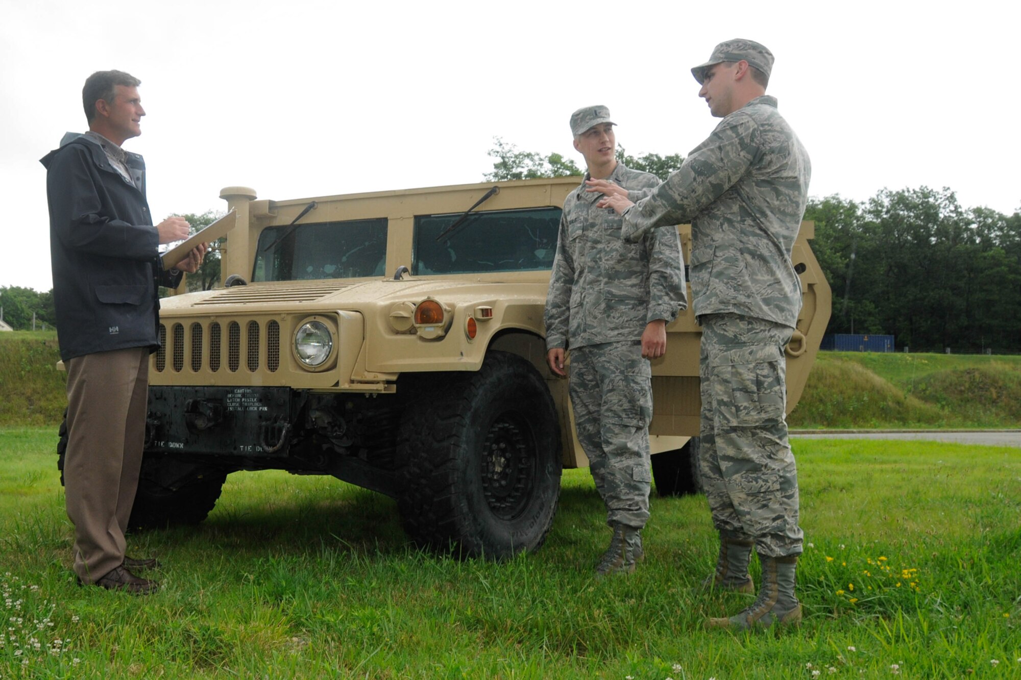Following a Theater Battle Control Division Industry Day, Don MacMilland, left, and U.S. Air Force 1st Lts. Aaron Zadalis, center, and Matt Cignoli inspect an M1145 Humvee at Hanscom Air Force Base, Mass., July 16. The M1145 will house a new Mobile Communication System for tactical air control party Airmen. The system will allow TACPs to control close-air support aircraft from the safety of an armored vehicle by utilizing multi-channel/multi-band radios, full motion video receiver and a computer. (U.S. Air Force photo by Linda LaBonte Britt)