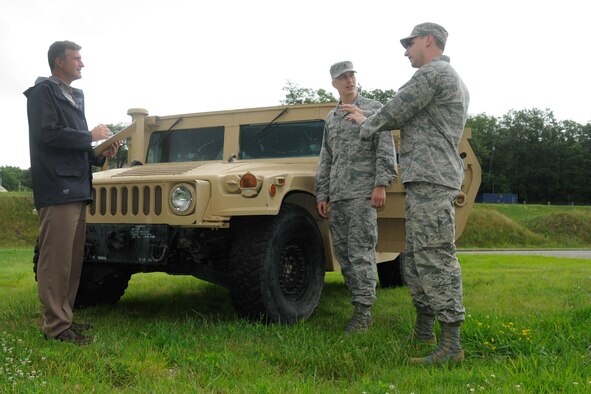 Following a Theater Battle Control Division Industry Day, Don MacMillan (left) and Air Force 1st Lts. Aaron Zadalis (center) and Matt Cignoli inspect an M1145 Humvee at Hanscom Air Force Base, Mass., July 16, 2014. The M1145 will house a new Mobile Communication System for tactical air control party Airmen. The system will allow TACPs to control close-air support aircraft from the safety of an armored vehicle by utilizing multi-channel/multi-band radios, full motion video receiver and a computer. (U.S. Air Force photo/Linda LaBonte Britt) 


