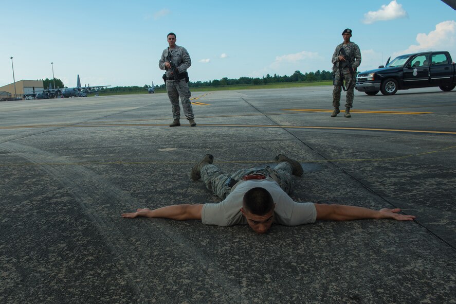 Members of the 23d Security Forces Squadron simulate apprehending unauthorized personnel on the flight line at Moody Air Force Base, Ga., July 22, 2014. During the exercise the unauthorized personnel was considered armed and dangerous. (U.S. Air Force photo by Airman 1st Class Ceaira Tinsley/Released)