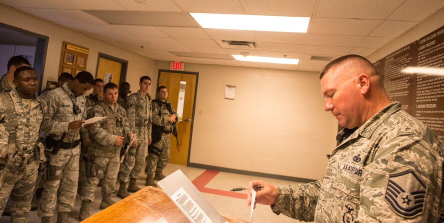 U.S. Air Force Master Sgt. Christopher Cook, 23d Security Forces Squadron mid-shift flight chief, addresses the flight during guardmount at Moody Air Force Base, Ga., July 22, 2014. Guardmount is a nightly briefing done before the start of the shift to issue mission-critical information so that everyone is on the same page.(U.S. Air Force photo by Airman 1st Class Ceaira Tinsley/Released)