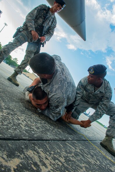 Members of the 23d Security Forces Squadron simulate taking down an unauthorized personnel on the flight line at Moody Air Force Base, Ga., July 22, 2014. The training exercise was performed to ensure the Airmen follow the correct procedures when apprehending an armed and unauthorized person. (U.S. Air Force photo by Airman 1st Class Ceaira Tinsley/Released)