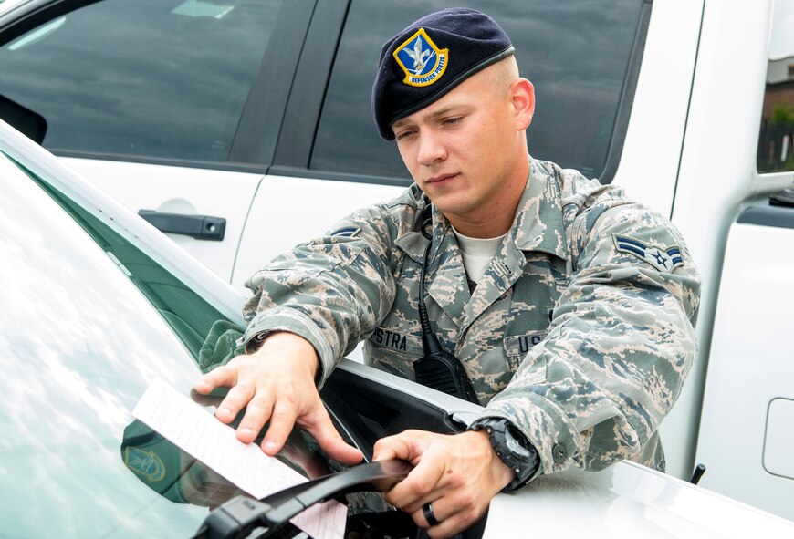 U.S. Air Force Airman 1st Class William Terpestra, 23d Security Forces Squadron patrolman, issues a traffic citation at Moody Air Force Base, Ga., July 21, 2014. Anyone who receives more than 12 points from traffic citations loses their driving privileges on base. (U.S. Air Force photo by Airman 1st Class Ceaira Tinsley/Released)