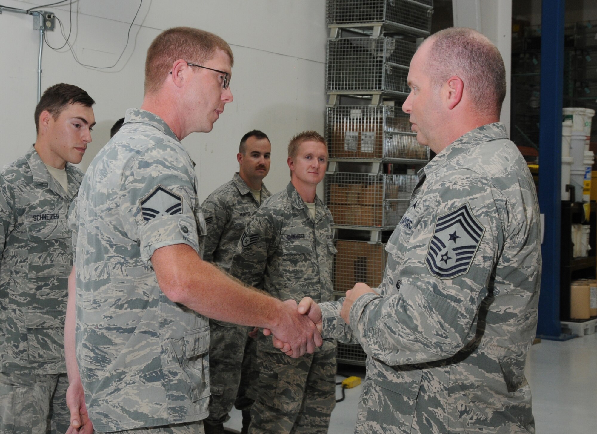 U.S. Air Force Master Sgt. Michael Moore, 270th Air Traffic Control Squadron, is coined by Chief Master Sgt. James W. Hotaling, the Air National Guard Command Chief, during Hotaling's visit to Kingsley Field, Klamath Falls, Ore. July 15, 2014. Hotaling spent the day meeting and speaking with the Airmen of the 173rd FW and 270th Air Traffic Control Squadron. (U.S. Air National Guard photo by Master Sgt. Jennifer Shirar/Released)
