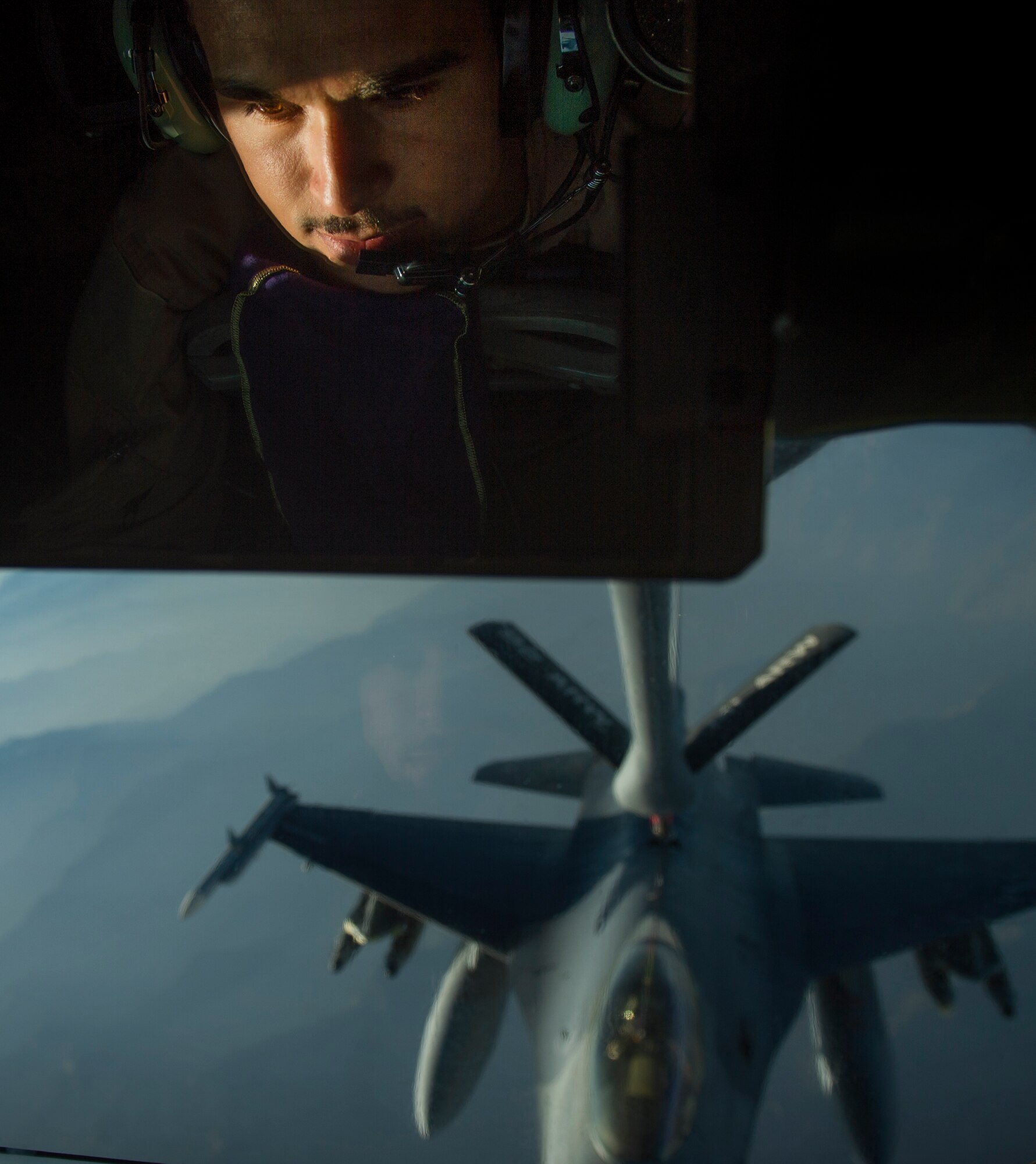 Airman 1st Class Jordan Gese, 340th Expeditionary Air Refueling Squadron boom operator, off-loads fuel to an F-16C Fighting Falcon during an in-air refueling mission over Afghanistan, July 22, 2014. Gese, an Aberndeen, South Dakota native, is deployed the 93rd Aerial Refueling Squadron, Fairchild Air Force Base, Washington. (U.S. Air Force photo by Staff Sgt. Vernon Young Jr./Released)