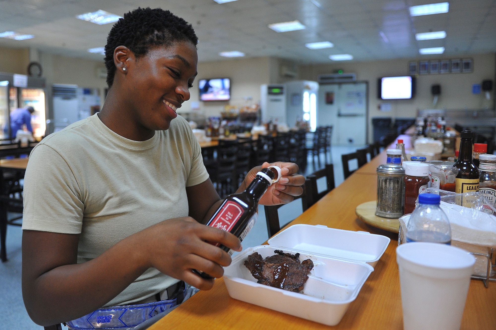 Senior Airman Chesley Taylor, 380th Expeditionary Force Support Squadron quality assurance, sits down to eat a steak cooked by the first sergeant’s council July 20, 2014, at an undisclosed location in Southwest Asia. The first sergeant’s midnight Motown barbeque occurs every second Sunday outside of Roy’s Dining Facility. (U.S. Air Force photo by Tech. Sgt. Russ Scalf/Released)