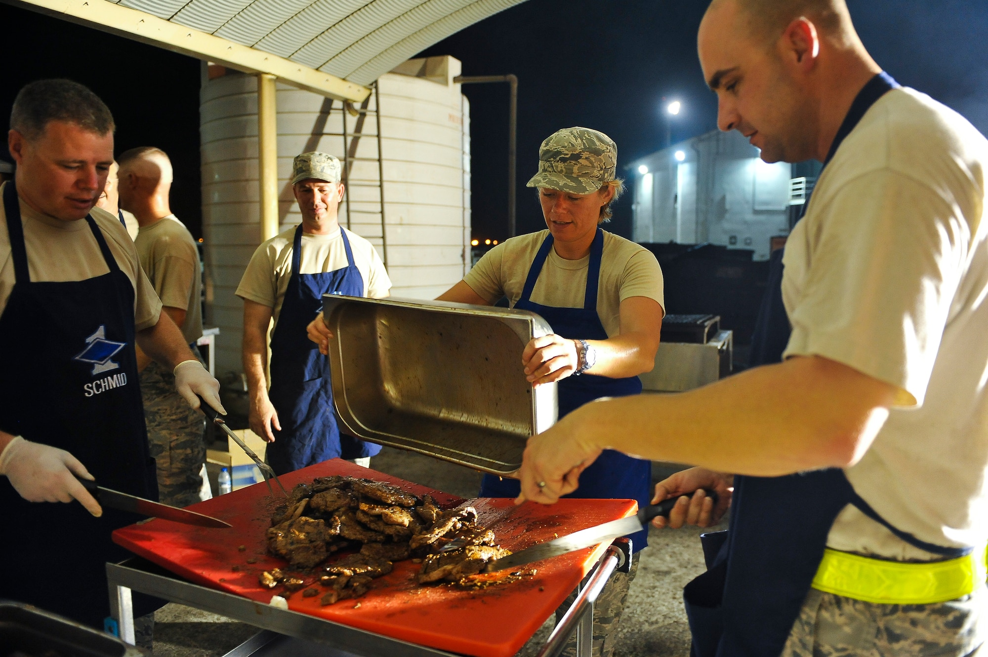 First Sergeants from the 380th Air Expeditionary Wing prepare steaks for maintenance and operations workers July 20, 2014, at an undisclosed location in Southwest Asia. The barbeque serves as a boost to the spirit of the Airmen working the night shift. (U.S. Air Force photo by Tech. Sgt. Russ Scalf/Released)
