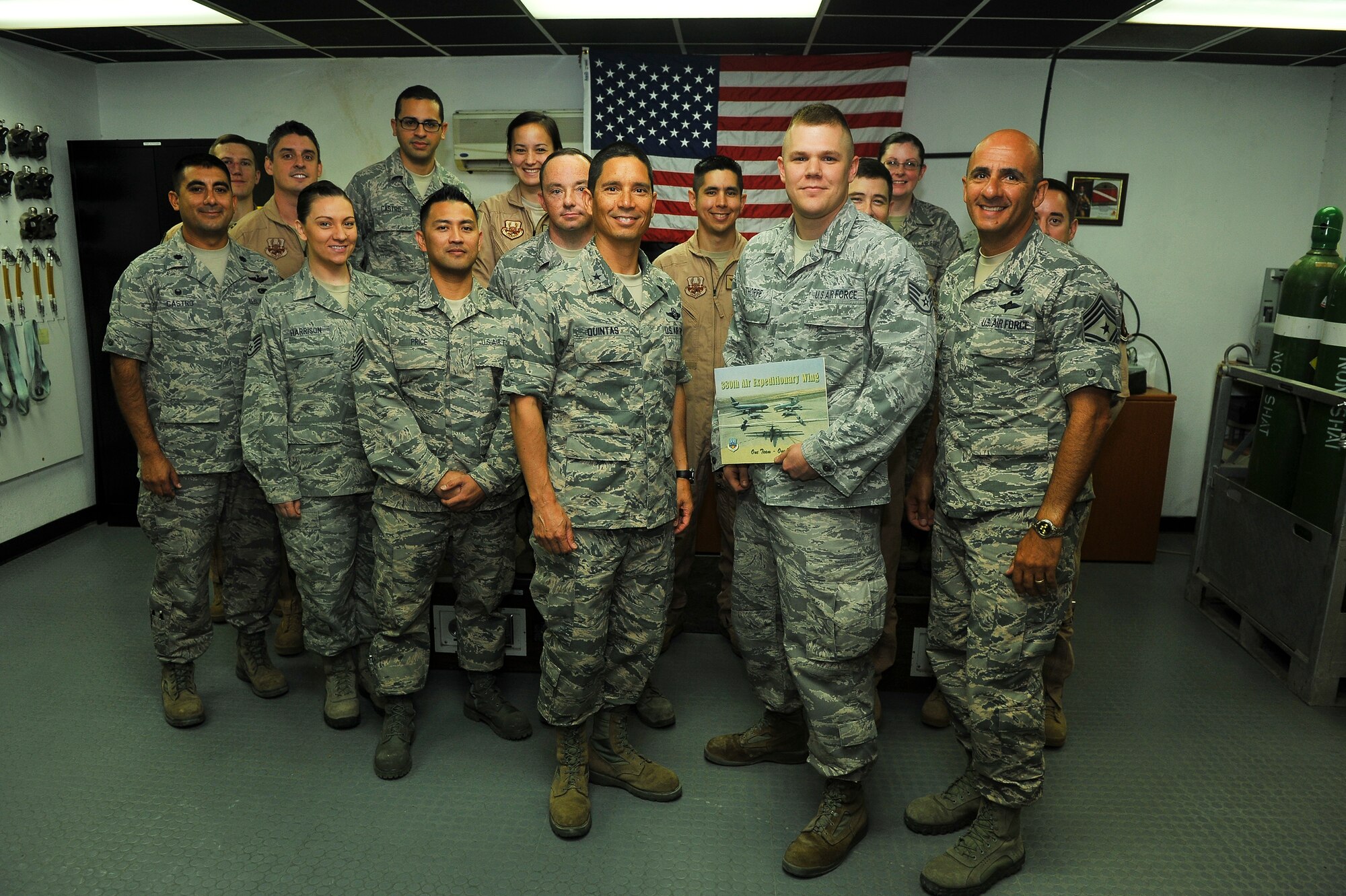 Air Force Brig. Gen. John T. Quintas, 380th Air Expeditionary Wing commander, and Chief Master Sgt.Samer Alkhoury, 380th Air Expeditionary Wing command chief, present Staff Sgt. John Thorpe, 99th Expeditionary Reconnaissance Squadron, with a warrior of the week certificate July 24, 2014, at an undisclosed location in Southwest Asia. Thorpe is a Boise, Idaho native, and is deployed from Beale Air Force Base, Calif. (U.S. Air Force photo by Tech. Sgt. Russ Scalf/Released)