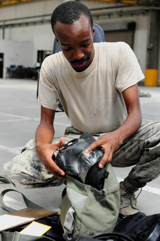 Airman 1st Class William Johnson, Jr., 39th Logistics Readiness Squadron material management journeyman, performs a gas mask inspection at the mobility warehouse July 22, 2014, Incirlik Air Base, Turkey. The individual protective equipment section is responsible for issuing IPE. (U.S. Air Force photo by Staff Sgt. Eboni Reams/Released)