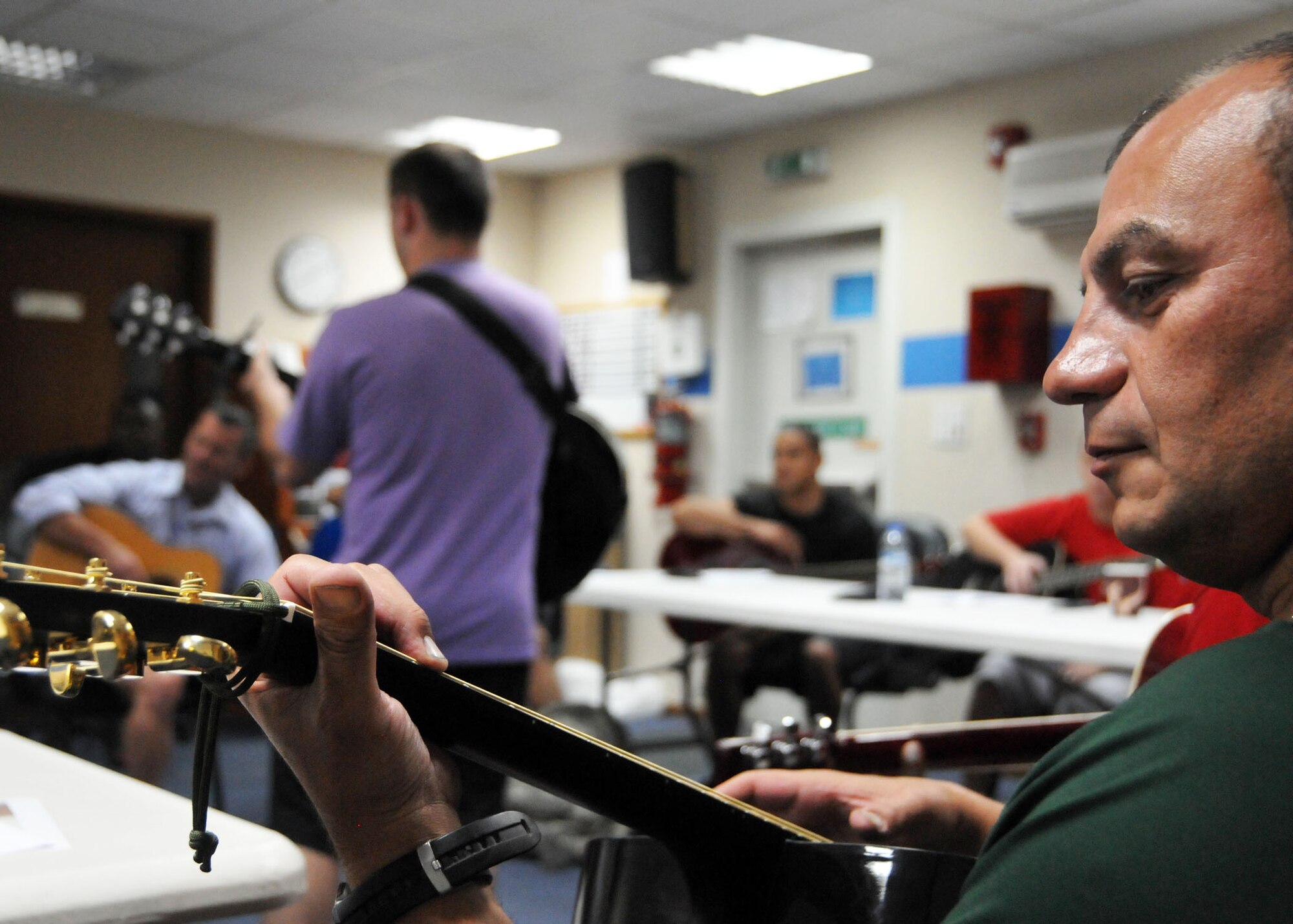 Air Force Tech. Sgt. Carmine Sammarco strums his guitar during an evening guitar class taught at the 380th Air Expeditionary Wing’s chapel July 16, 2014. Sammarco was one of 15 students who signed up for the beginning guitar course offered to individuals serving at the wing’s undisclosed location in Southwest Asia. (U.S. Air Force photo by Senior Master Sgt. Eric Peterson/Released)